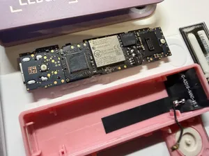 A Ledger hardware wallet that has been opened to reveal the original chip, plus an additional chip with an antenna that was added by an attacker